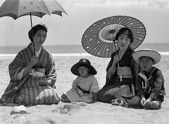 日傘をさす女性と子供たち